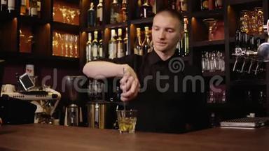 酒吧内部的年轻酒吧服务员把威士忌倒在玻璃里，然后<strong>拿来</strong>给客人